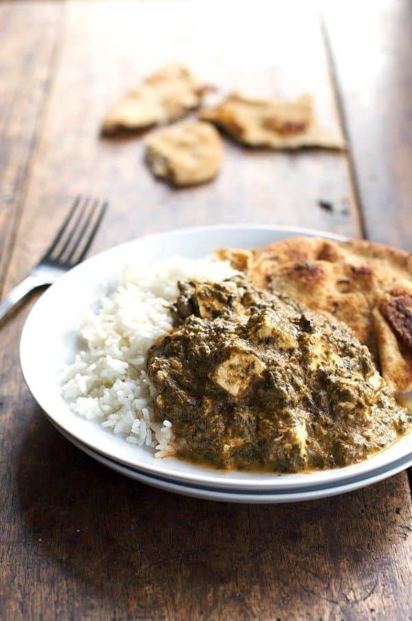 Palak paneer with rice on a plate.