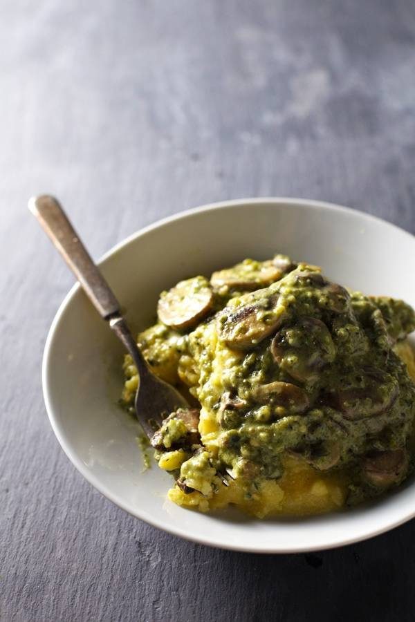 Creamy Poblano Mushrooms with Polenta in a white bowl with a fork.