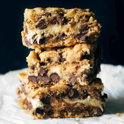 Stacks of chocolate chip cookie cheesecake brownies.