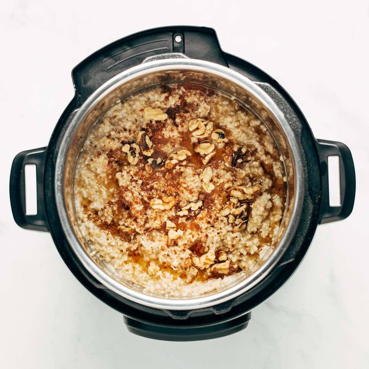 Cooked oatmeal in the Instant Pot with nuts and brown sugar on top.