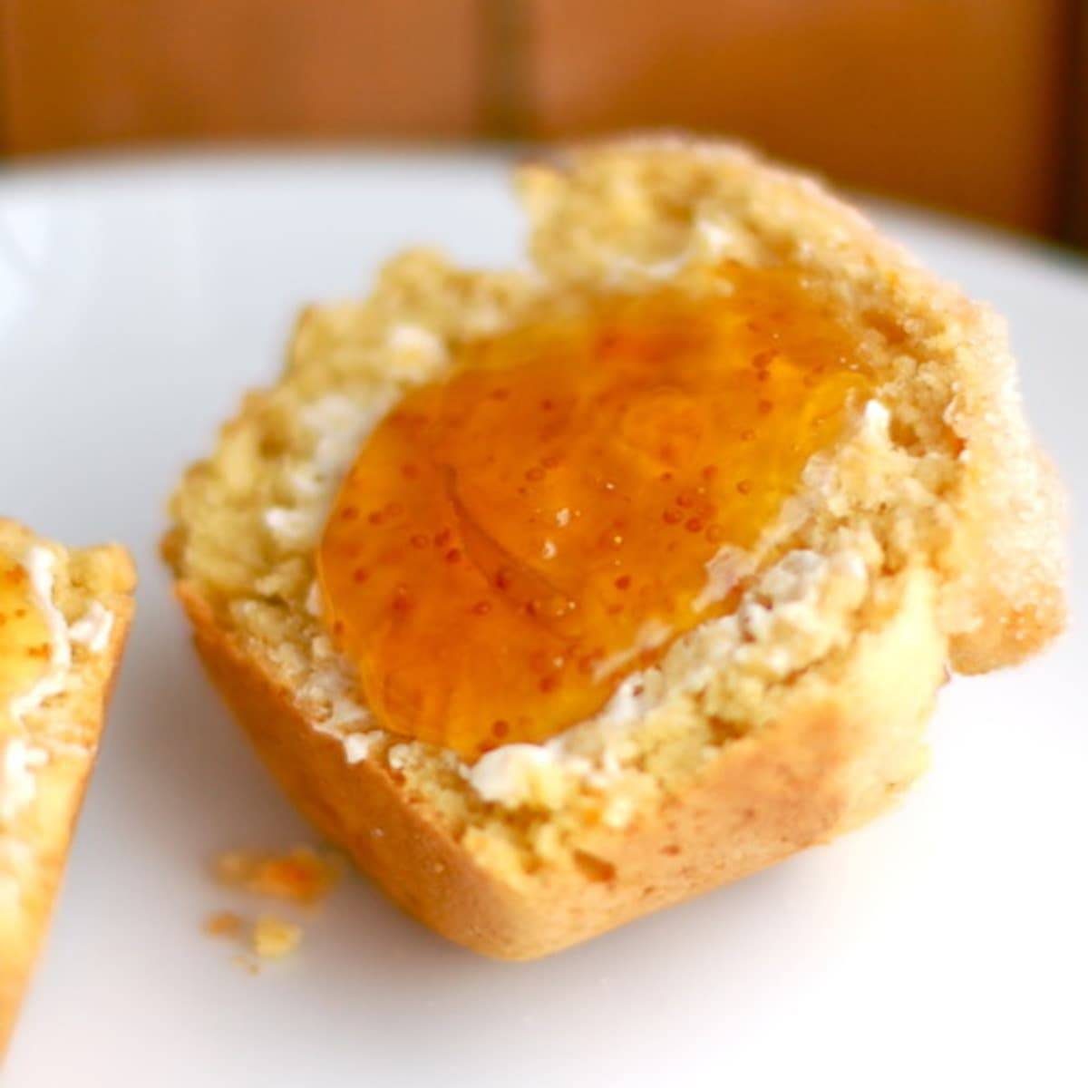 Sugar-dusted sweet potato muffins with fruit preserves spread.