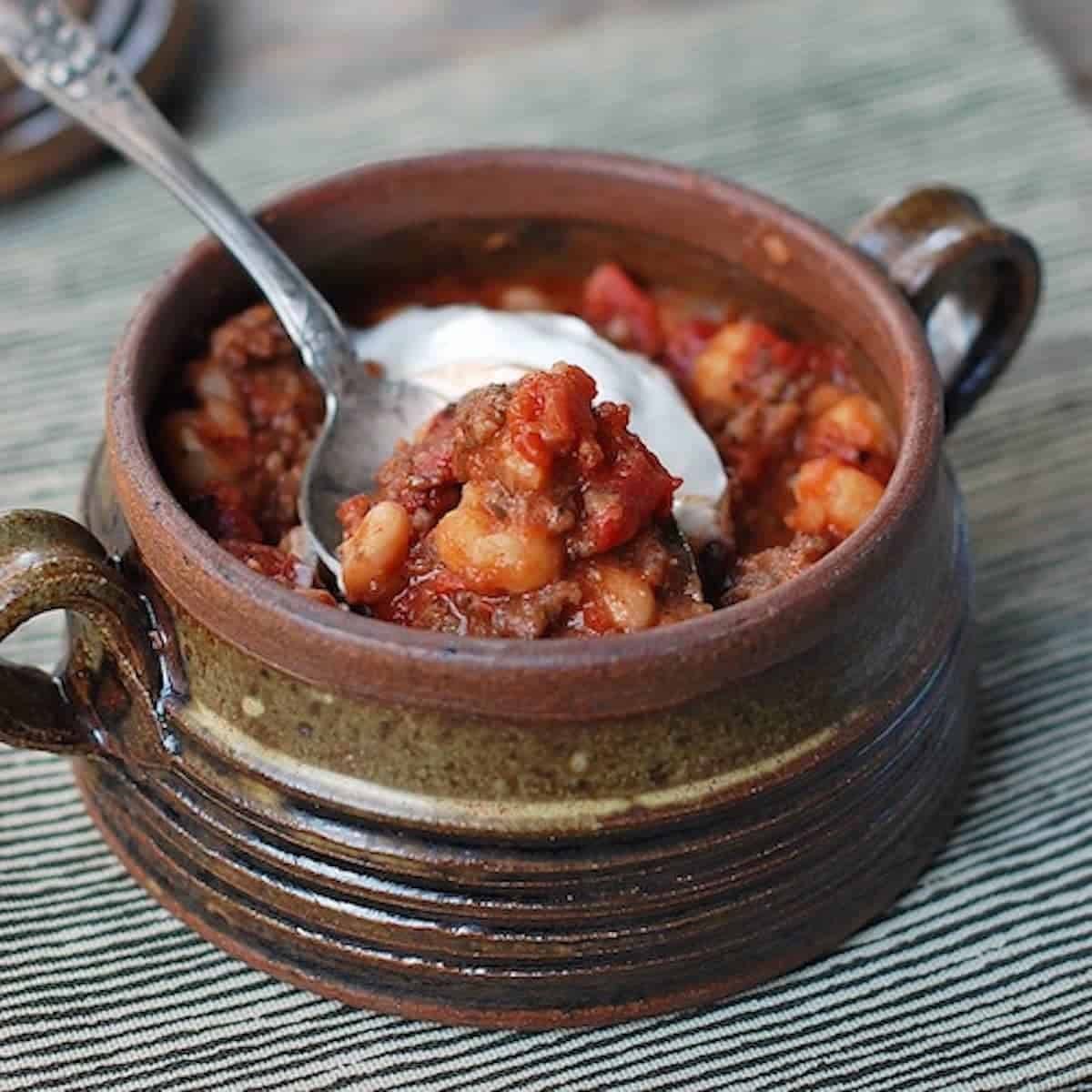 White bean chili in a bowl with sour cream.